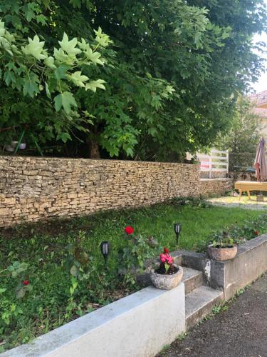 a garden with a retaining wall and some flowers at 'De Maîche avec vous', 6 à 8 personnes in Maîche