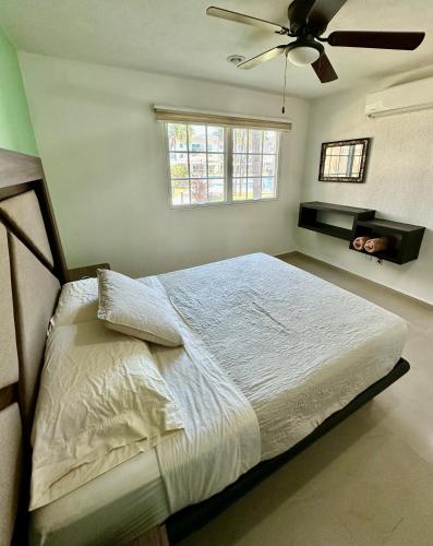 a bedroom with a bed with a ceiling fan at PARAISO ESCONDIDO e126 in Acapulco