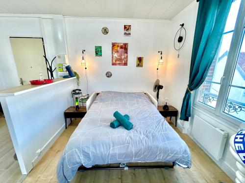 a bedroom with a bed with a blue object on it at Le Vintage, centre, parking gratuit in Pont-sur-Yonne