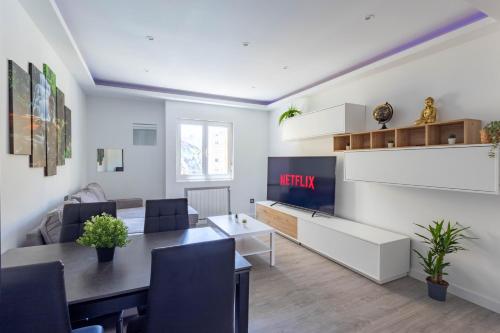 ein Wohnzimmer mit Tisch und Fernseher in der Unterkunft Santander Centro I 4 hab I Ocio I Wifi I Moderno in Santander