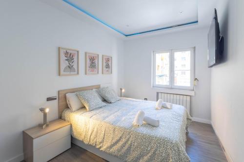 ein Schlafzimmer mit einem Bett und einem Fenster in der Unterkunft Santander Centro I 4 hab I Ocio I Wifi I Moderno in Santander