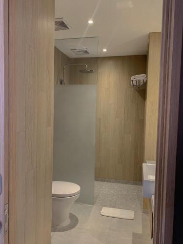 a bathroom with a toilet and a sink at Swiss-Belinn Indramayu in Indramayu