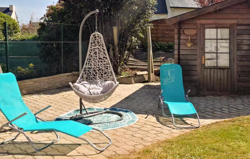 une terrasse avec 2 chaises et une balançoire dans l'établissement Cozy Home In Plouguerneau With Wifi, à Plouguerneau