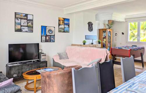 un salon avec une télévision et une table dans l'établissement Cozy Home In Plouguerneau With Wifi, à Plouguerneau