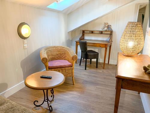 a living room with a chair a table and a piano at Hôtel de l'Horloge in Avignon
