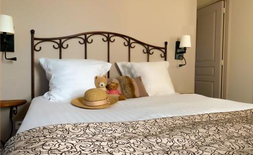two teddy bears sitting on top of a bed at Hôtel de l'Horloge in Avignon
