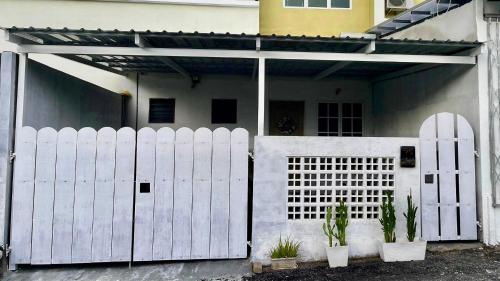 a white fence in front of a house at Helena’s Studio Suite Gerik in Gerik