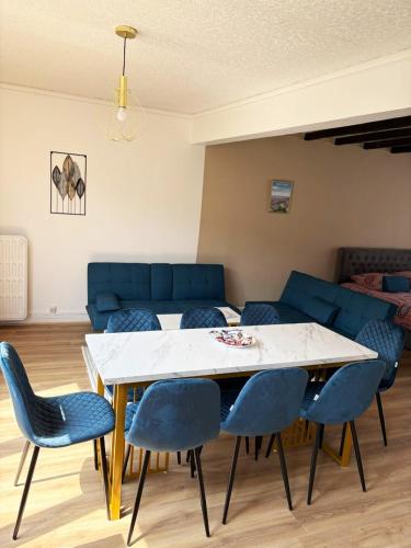 un salon avec une table et des chaises bleues dans l'établissement Cosy à 100m de la mer-En plein cœur du Portel, à Le Portel