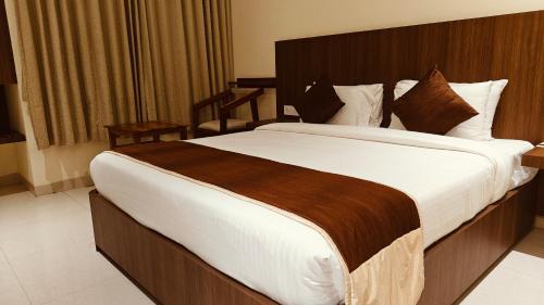 a bedroom with a large bed in a hotel room at Alps Residency - A Bergamont Hotel, Krishnagiri in Krishnagiri
