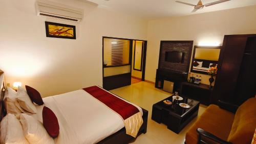 a hotel room with a bed and a tv at Alps Residency - A Bergamont Hotel, Krishnagiri in Krishnagiri