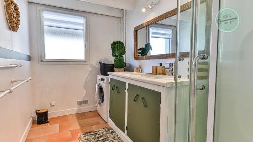 ein Badezimmer mit Waschbecken und Waschmaschine in der Unterkunft Villa Ocean in Les Bussolleries
