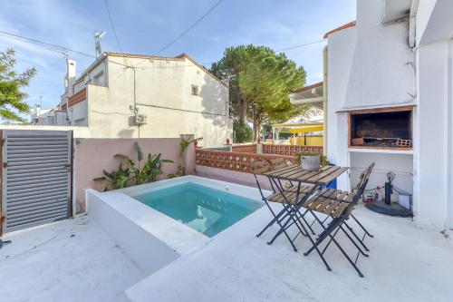 a patio with a table and chairs and a swimming pool at Casa con piscina privada y comunitaria in Empuriabrava