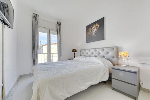 a white bedroom with a bed and a window at Casa con piscina privada y comunitaria in Empuriabrava