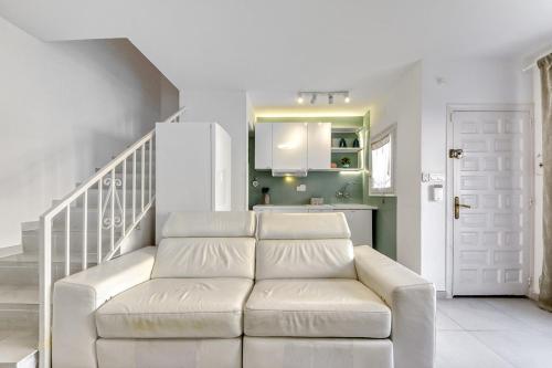 a white couch in a living room with a staircase at Casa con piscina privada y comunitaria in Empuriabrava