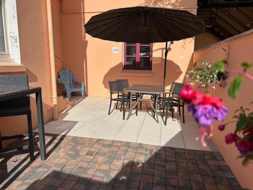 a patio with a table and chairs and an umbrella at Villa Antibes Chez Celine in Étaples