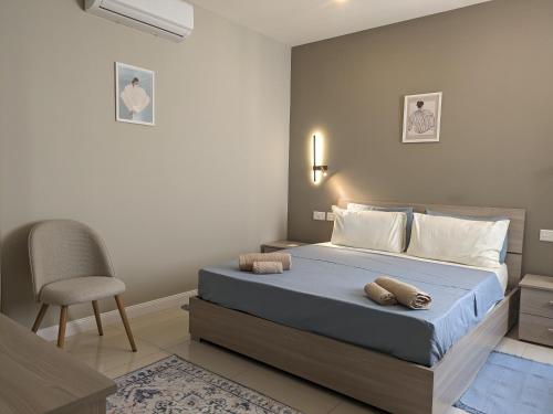 a bedroom with a bed and a chair in it at Salus Holiday Apartment in Victoria
