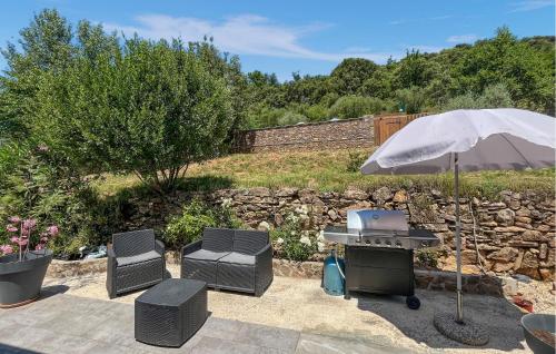 un barbecue et des chaises avec un parasol dans l'établissement Gorgeous Home In St-Florent-Sur-Auzonne, à Saint-Florent-sur-Auzonnet
