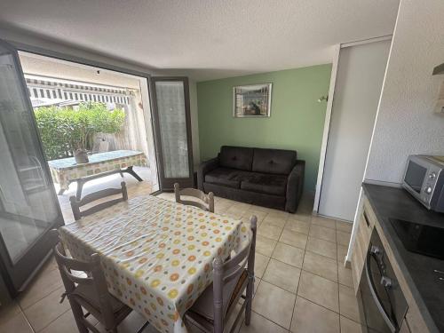 un salon avec une table et un canapé dans l'établissement Appartement - piscine collective - terrasse - place de parking, à Saintes-Maries-de-la-Mer