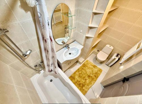 a bathroom with a tub and a sink and a mirror at New private Dumeniuc residence in Chişinău