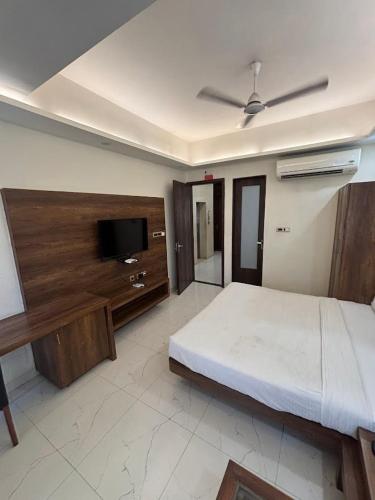 Un dormitorio con una cama y un televisor de pantalla plana. en Hotel Ada Regency, en Bhopal