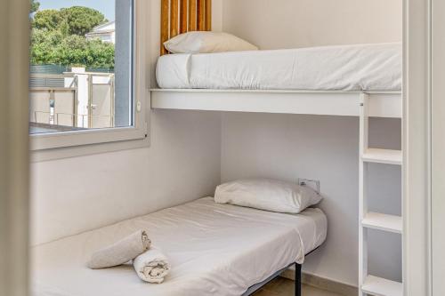 a room with two bunk beds and a window at Apartamento L'escala - 1r Piso in L'Escala