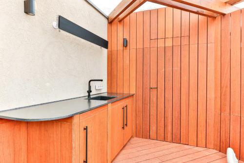 - une cuisine avec un évier et un mur en bois dans l'établissement Luxurious apartment 1BR-2P - Place de la Concorde, à Paris
