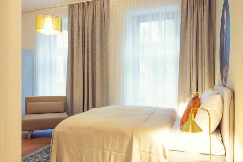 a bedroom with a bed and a chair and a window at LeonArt Living 11 in Graz