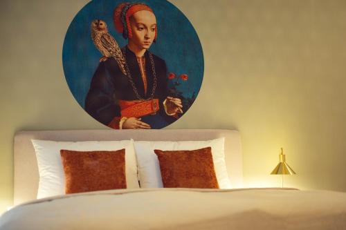 a painting of a woman with an owl above a bed at LeonArt Living 11 in Graz