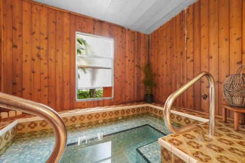 a swimming pool with wooden walls and a window at Golf Cart-Jacuzzi-Surfing Abode on Hutchinson Island in Fort Pierce