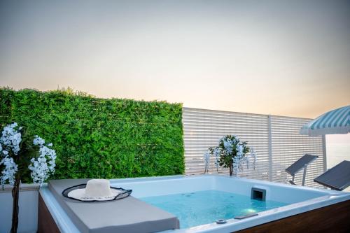 a bath tub in a yard with a green hedge at Amarè Luxury Suite And Room Vista Mare in Bari