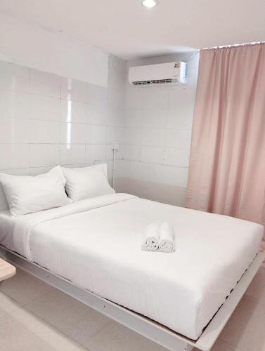 a white bed with two white towels on it at xx Mitr INN Sukhumvit 2 - BTS Nana มิตร อินน์ สุขุมวิทซอย 2 บีทีเอส นานา in Bangkok