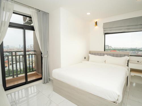 a bedroom with a white bed and large windows at TV-Tower 1 in Phnom Penh