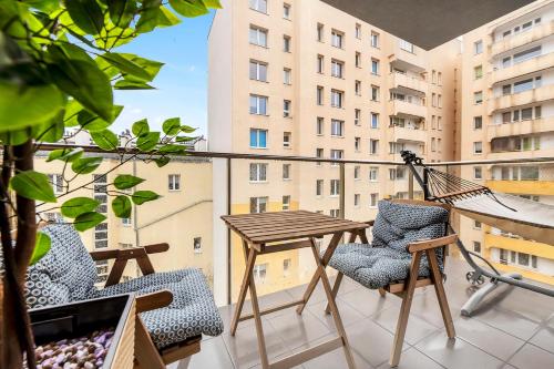 a balcony with a wooden table and chairs at Lumina I 3BR Apartment with Balcony I Parking I 2 Bathrooms I near Center in Warsaw