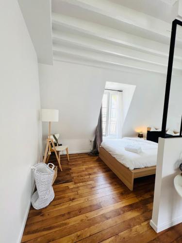 une chambre avec un lit et un parquet dans l'établissement Welcome to Montmartre, à Paris
