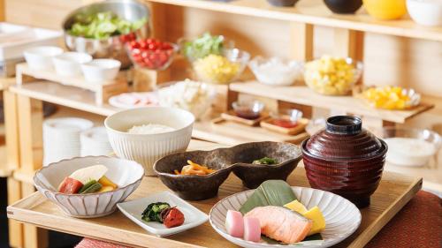 a wooden tray with bowls of food on a table at Hotel Sunroute Hikone in Hikone