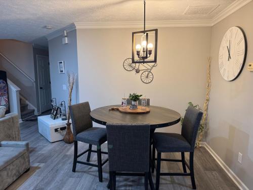 a dining room with a table and chairs and a clock at ThrillStay Braves & Six Flags Family House in Lithia Springs