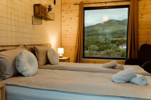 a bedroom with two beds and a large window at Tiny House Sage - ElysianFields in Sadu