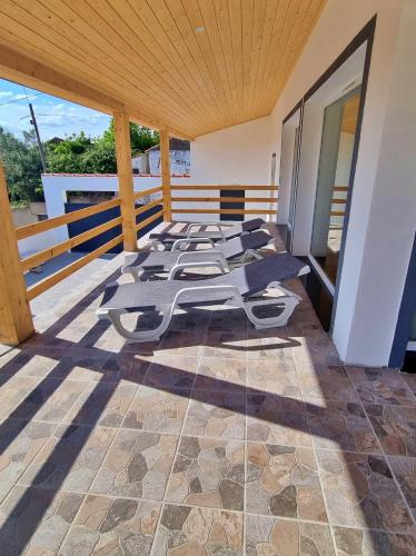a room with a row of chaise lounges on a roof at Villa com Piscina Privada para 6 Pessoas Casa dos Filhos dos Padeiros in Figueira e Barros