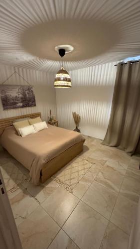 une chambre avec un grand lit et un lustre dans l'établissement Appartement Le Pontet, au Pontet