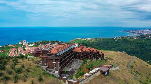 a building on top of a hill next to the ocean at Sera Lake Resort Hotel Spa & Aparts in Trabzon