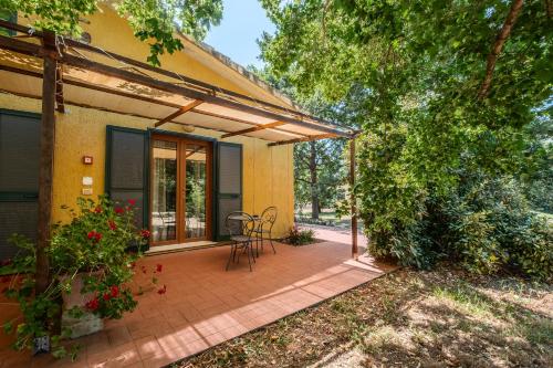 a patio of a house with a table and chairs at Rosaspina - Appartamento 6 in Capalbio