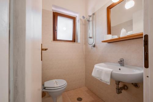 a bathroom with a white toilet and a sink at Rosaspina - Appartamento 6 in Capalbio
