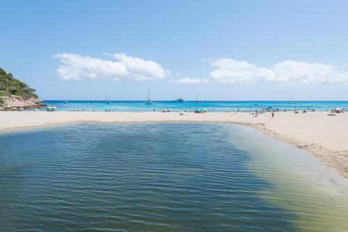 a beach with a group of people on the beach at Canyamel A in Canyamel