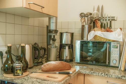 a kitchen counter with a microwave and a bread at Luxus-Lodge Kaiser Franz Josef im SCHILLER in Bad Gastein