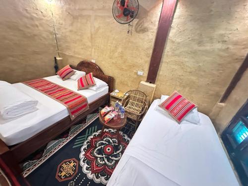 a room with two beds and a table at Mường Lống Ecogarden in Kỳ Sơn