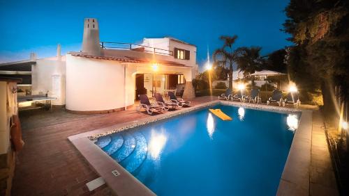 a swimming pool in front of a house at night at Golfinho - Private Pool - 10 Guests - Albufeira in Albufeira