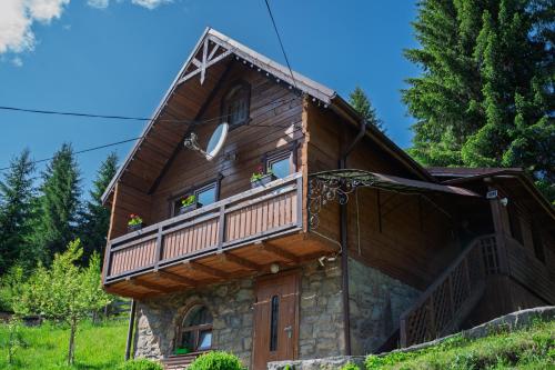 a house with a balcony on the side of it at Котеджі "У Яни" in Yablunytsya