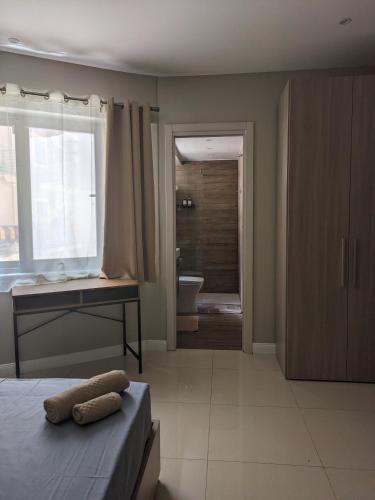 a bedroom with a bed and a desk and a bathroom at Salus Holiday Apartment in Victoria
