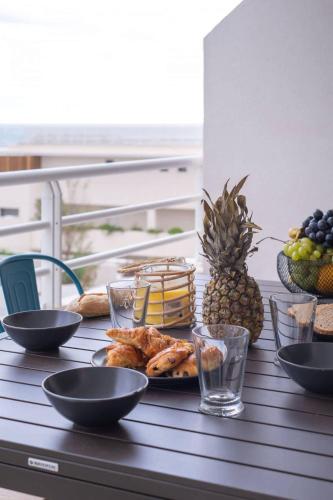 - une table avec une assiette de nourriture et de fruits dans l'établissement Valras-Loc Archipel Panarea Terrasse et Vue Mer, à Valras-Plage