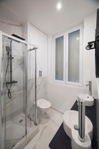 La salle de bains est pourvue d'une douche en verre et de 2 lavabos. dans l'établissement Modern apartment in Nation, à Paris